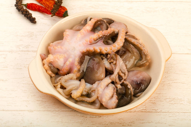 Raaka mustekala valkoinen levy valmis ruoanlaittoon yli puinen tausta
 - Valokuva, kuva