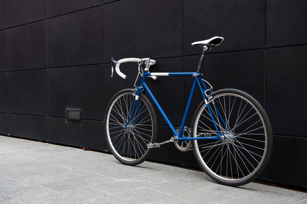 Vintage blue city bicycle on a black wall - Photo, Image