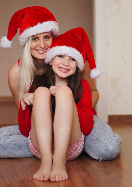 beautiful mother and daughter with santa hats - Φωτογραφία, εικόνα