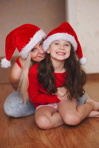 beautiful mother and daughter with santa hats - Fotografie, Obrázek