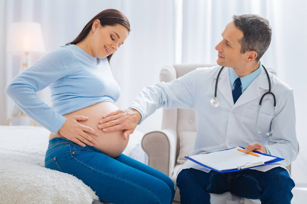 Young pregnancy sitting near her doctor - Foto, immagini