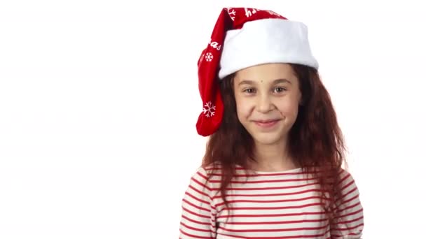 ein Mädchen mit Weihnachtsmannmütze lächelt in die Kamera - Filmmaterial, Video