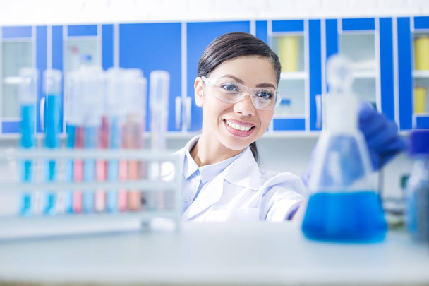 Nice happy woman working in the chemical lab - Фото, зображення