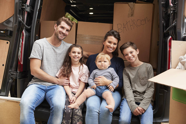 Family Sitting In Back Of Removal Truck - Foto, Imagen