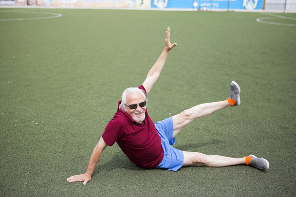 Ανώτερος άνθρωπος άσκηση σε ένα ανοιχτό γήπεδο - Φωτογραφία, εικόνα