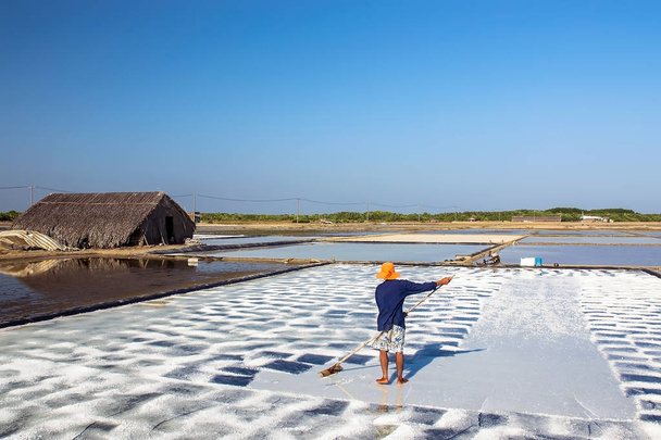 CIUDAD DE HOCHIMINH VIETNAM: El agricultor que cosecha sal en Can Gio, ciudad de Hochiminh, Vietnam
. - Foto, Imagen