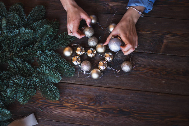 Decorator holds christmas toys in her hands, start to prepare christmas wreath - Fotoğraf, Görsel