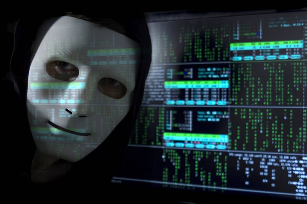 Blure digital. Человек-хакер в маске на фоне двоичного кода
. - Фото, изображение