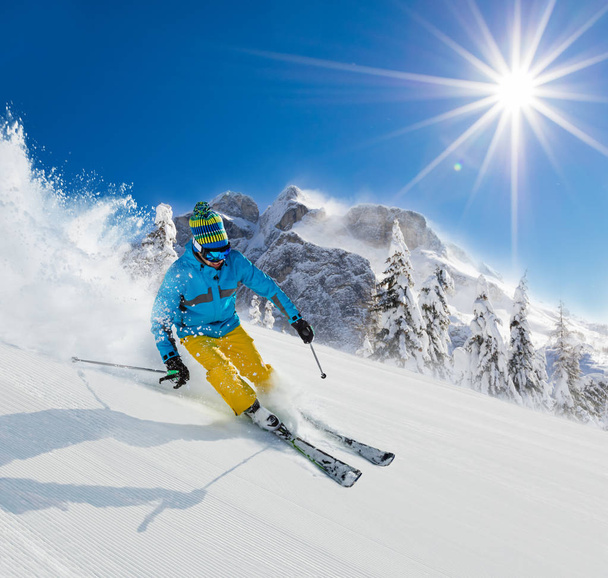 Skier on piste running downhill in Alpine landscape. - Фото, зображення
