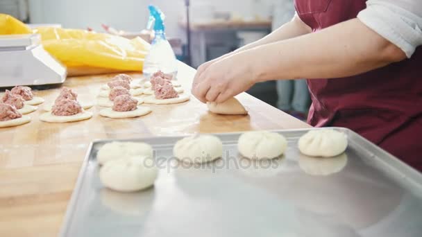 Доросла жінка випікає і формує м'ясні пироги в пекарні
 - Кадри, відео