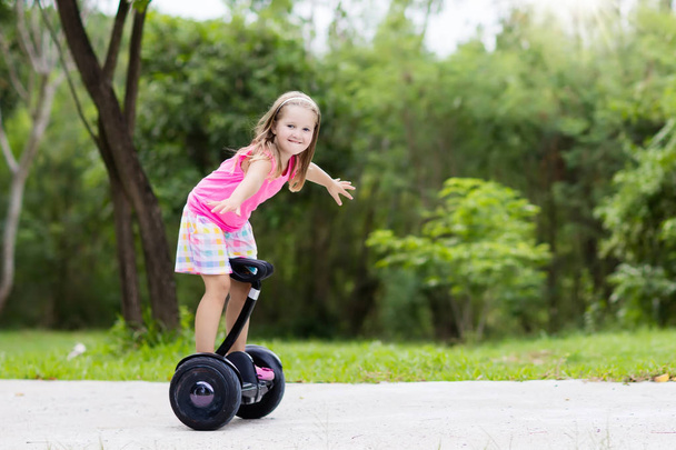 Criança a bordo. Crianças montando scooter
 - Foto, Imagem
