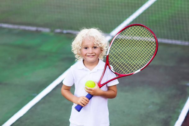 Bambino che gioca a tennis sul campo all'aperto
 - Foto, immagini
