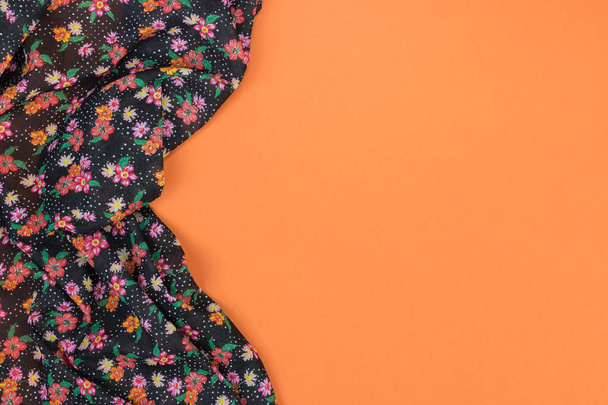 Floral pattern tablecloth on empty orange background. Top view w - Photo, Image