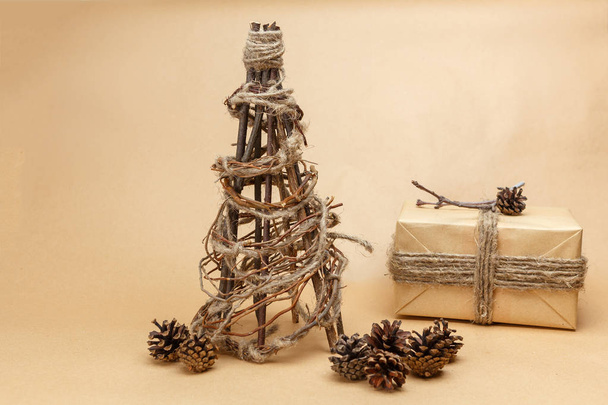 Nieuwe jaar boom handgemaakte in eco stijl met cadeau verpakt in papier en pinecones - Foto, afbeelding