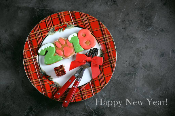 Uudenvuoden lautasen hunajakekseillä, lusikalla ja haarukalla. Uusi vuosi 2018
. - Valokuva, kuva