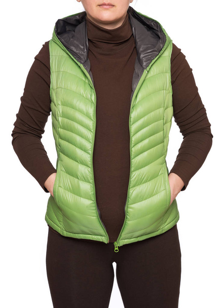 Mladá žena na sobě světle zelená s kapucí sbalitelný dolů puffer vesta izolovaných na bílém pozadí - Fotografie, Obrázek