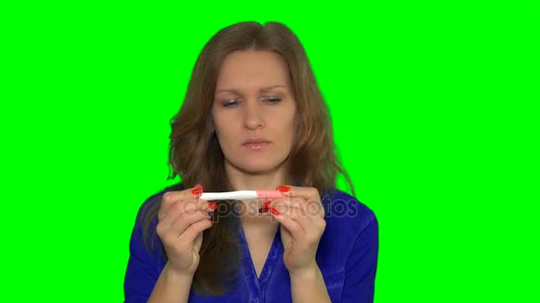 Mujer preocupada comprobando prueba de embarazo sentado
 - Imágenes, Vídeo