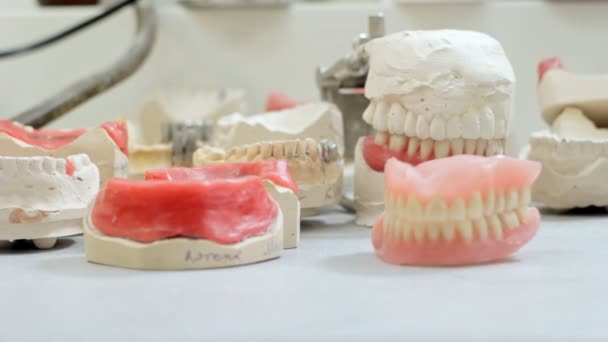 Prótesis dentista toma una dentadura postiza de la mesa de trabajo
 - Metraje, vídeo