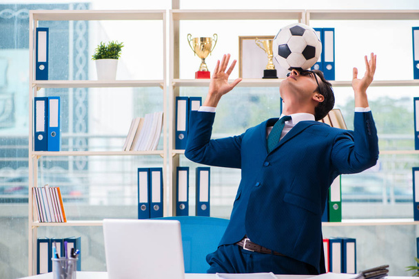 Бизнесмен играет в футбол в офисе - Фото, изображение