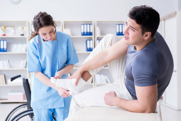 Врач и пациент во время осмотра на предмет травмы в больнице - Фото, изображение