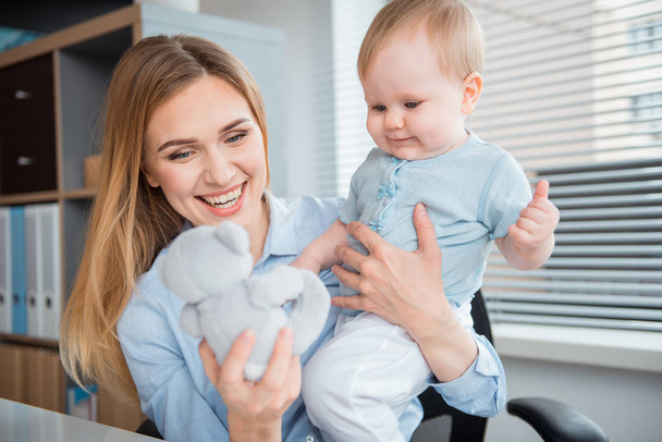 Outgoing woman and smiling baby at work - Foto, immagini