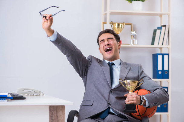 Businessman with prize cup for achievements in office - Photo, Image