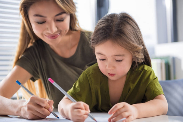Positive woman drawing picture with her daughter - Foto, imagen