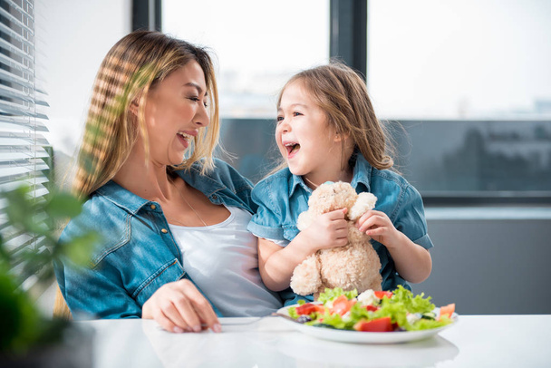 Happy parent and child eating at home - Φωτογραφία, εικόνα