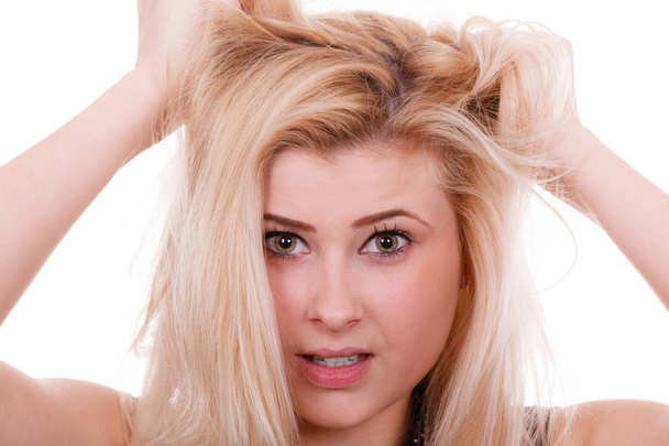 Blonde woman holding her dry hair - Foto, afbeelding