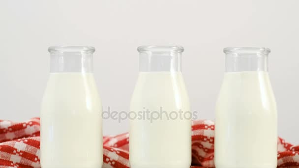 three milk bottles white background slide shot - Filmati, video