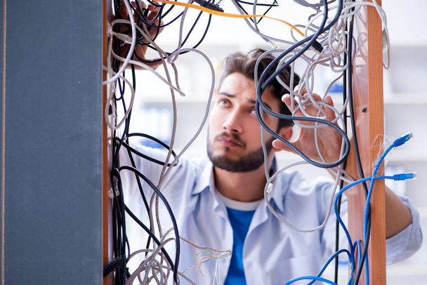 Computer repairman working on repairing network in IT workshop - Foto, afbeelding