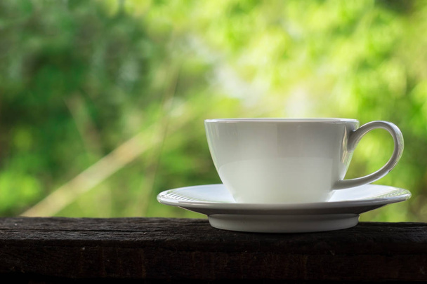 white coffee cup with green bokeh background - Fotoğraf, Görsel