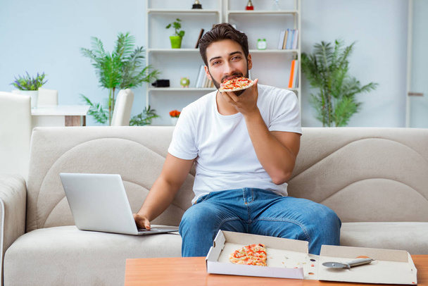 Man eating pizza having a takeaway at home relaxing resting - Photo, image