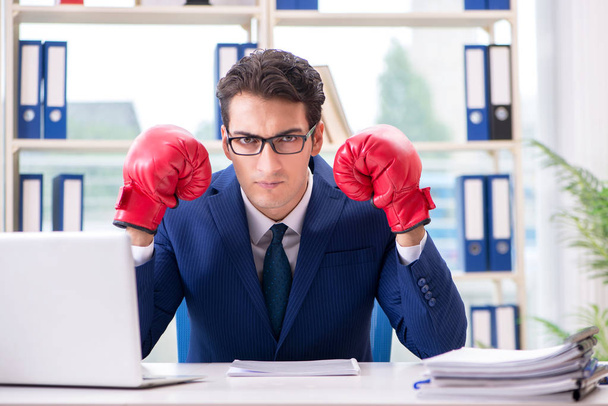Empresario con guantes de boxeo enojado en la oficina - Foto, imagen