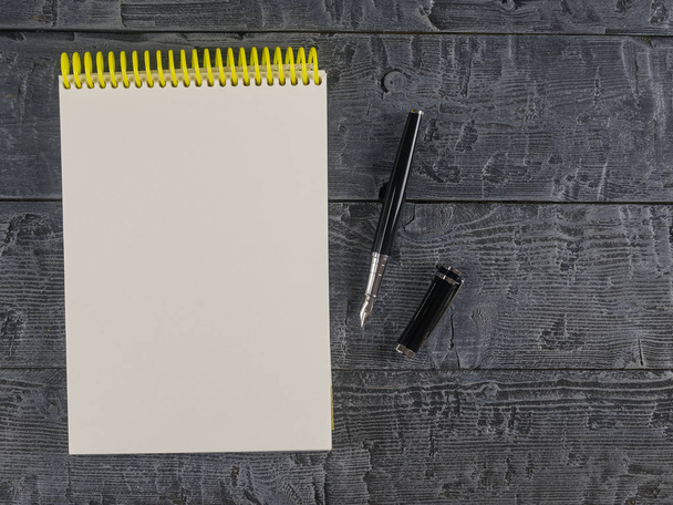 Caderno e caneta-tinteiro em uma mesa escura vista superior. Lugar para o seu texto
. - Foto, Imagem