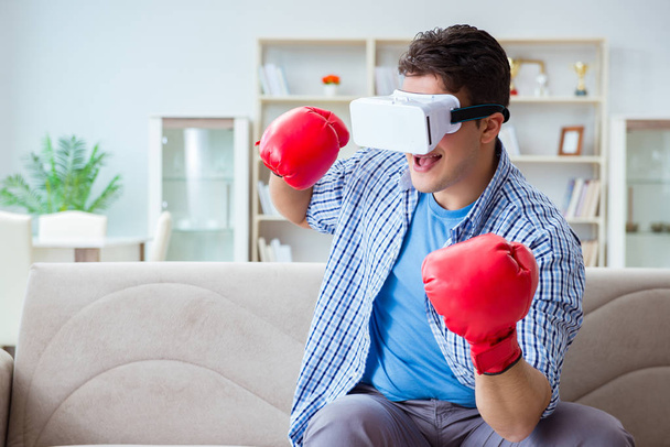 Человек в очках виртуальной реальности, играющий в бокс - Фото, изображение