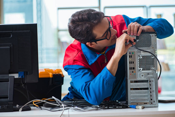 Reparador de computadoras trabajando en la reparación de computadoras en el taller de TI - Foto, Imagen