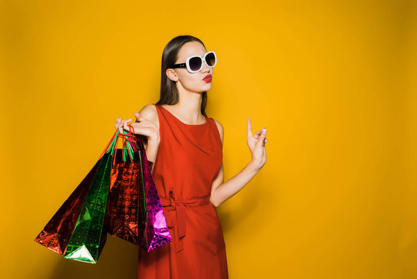 stylish attractive girl in sunglasses loves shopping on a black Friday - Foto, afbeelding
