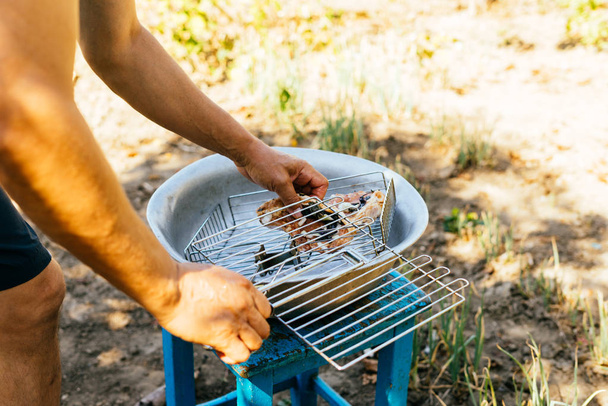 the man after the hunt is going to fry the raw deer meat on the grill for a picnic in the open air - 写真・画像