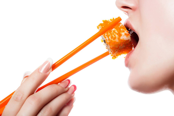 Beautiful girl holding sushi with a chopsticks, closeup - Photo, Image