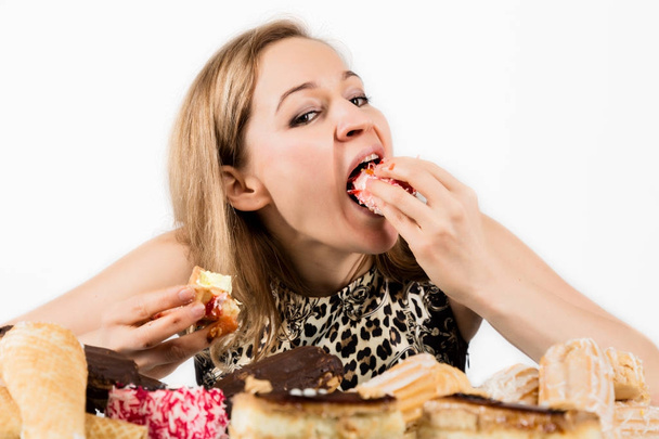 Young woman eating cupcakes with pleasure after a diet - Foto, afbeelding