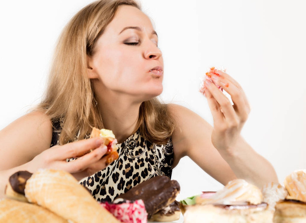 Young woman eating cupcakes with pleasure after a diet - Fotó, kép