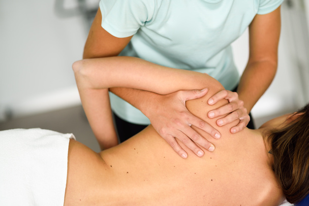 Professional female physiotherapist giving shoulder massage to a - Photo, image
