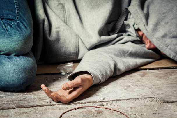 Un homme est un toxicomane avec une seringue qui utilise des drogues couchées sur le sol. Le concept d'anti-drogue. toxicomane masculin, seringue
. - Photo, image