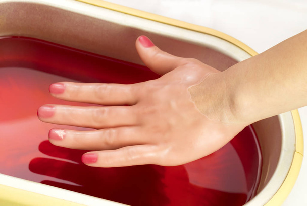Process paraffin treatment of female hands in beauty salon  - Φωτογραφία, εικόνα