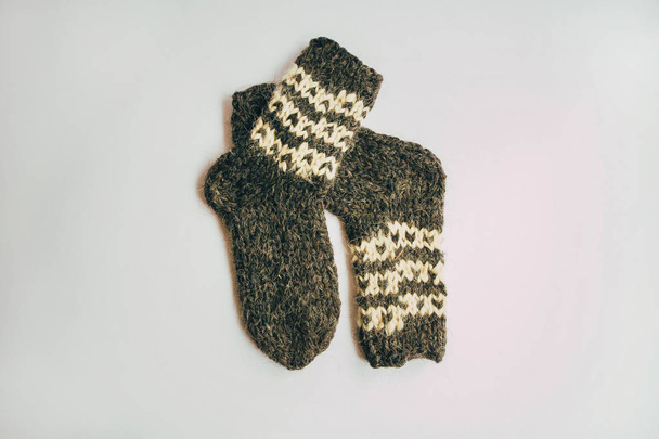Στοίβα χειροποίητο ζεστές κάλτσες πλεκτό φουλάρια γάντια από τραχύ μαλλί νήματα καφέ μπεζ γκρι στο τραπέζι από ξύλο. Κοντινό πλάνο. Φθινόπωρο Χειμώνας μόδα οικολογικών Kinfolk στυλ. - Φωτογραφία, εικόνα