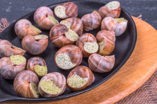 Ahşap arka plan üzerinde bir tabakta escargots de Bourgogne - Fotoğraf, Görsel