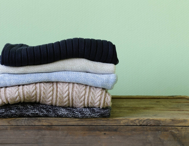 Ζεστά πλεκτά πουλόβερ σε ένα ξύλινο ράφι - Φωτογραφία, εικόνα