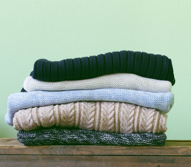 Ζεστά πλεκτά πουλόβερ σε ένα ξύλινο ράφι - Φωτογραφία, εικόνα