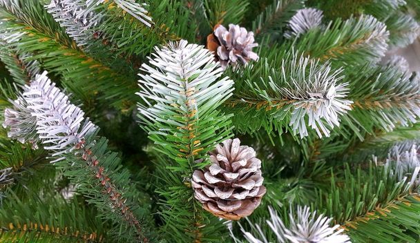 Umělé větve vánočního stromku s sněhu a kužely - Fotografie, Obrázek